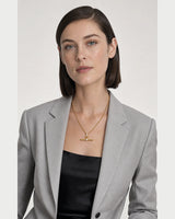 New York model wearing the Delphine toggle necklace with a pale-grey blazer