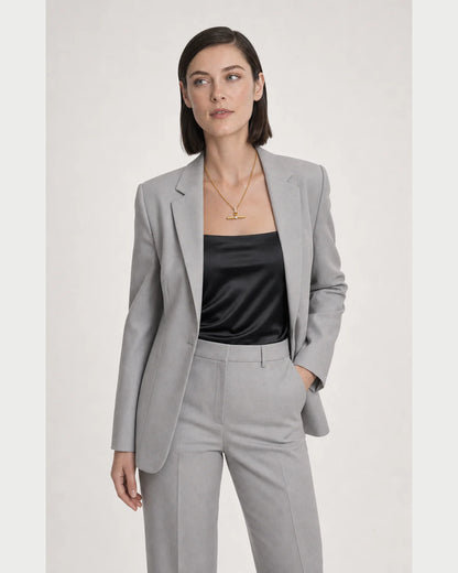 Wide grey-studio editorial portrait with the Delphine gold toggle necklace