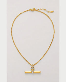 Delphine gold pavé toggle necklace on a seamless pale dove-grey background