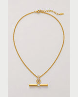 Delphine gold pavé toggle necklace on a seamless pale dove-grey background