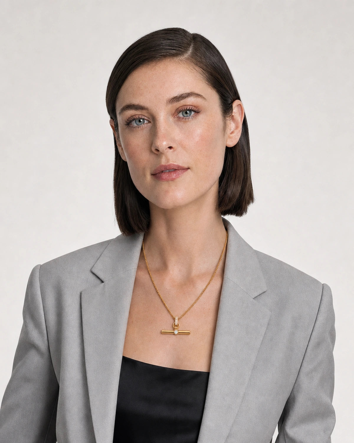 New York model wearing the Delphine toggle necklace with a pale-grey blazer
