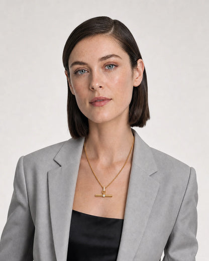 New York model wearing the Delphine toggle necklace with a pale-grey blazer