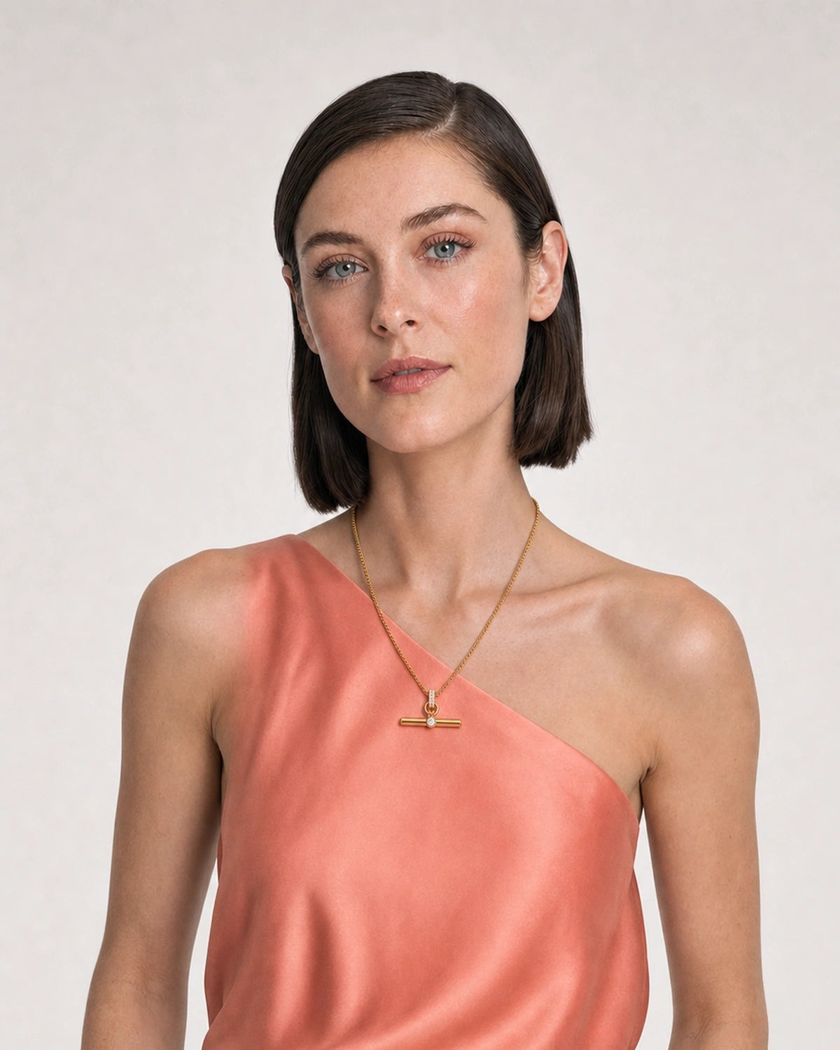 Model in coral silk and ivory summer linen wearing the Delphine pavé toggle necklace