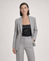Wide grey-studio editorial portrait with the Delphine gold toggle necklace