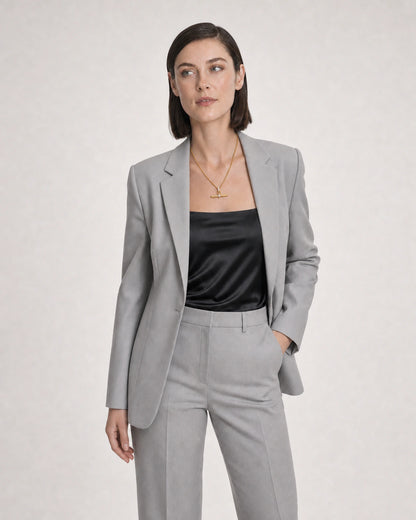Wide grey-studio editorial portrait with the Delphine gold toggle necklace