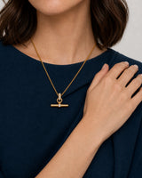 Jewellery-led hand and neckline detail of Beatrice wearing the Delphine toggle necklace