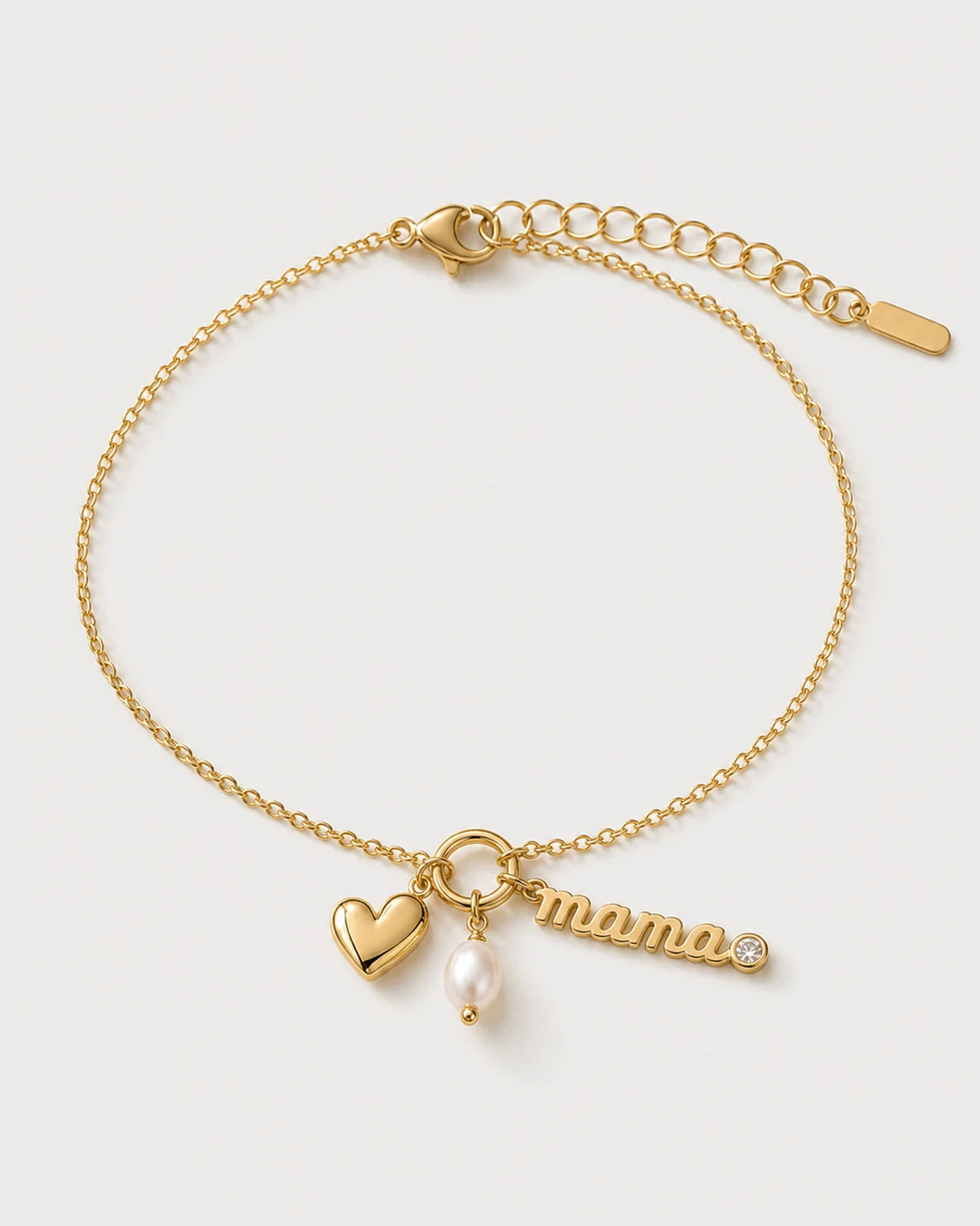 Elara gold mama charm bracelet on a seamless pale dove-grey studio background