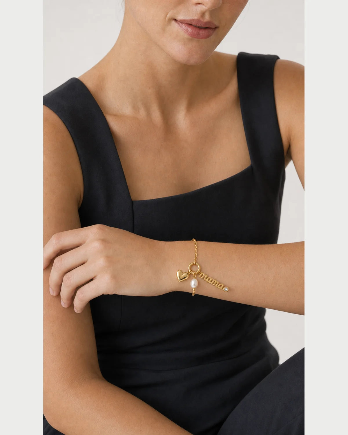 Close wrist view of the Elara mama, heart and pearl charm cluster