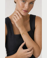 Human-scale portrait of the model wearing the Elara mama charm bracelet