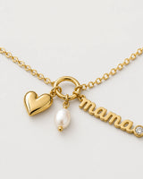 Macro of the Elara mama charm, puffed gold heart and oval white pearl