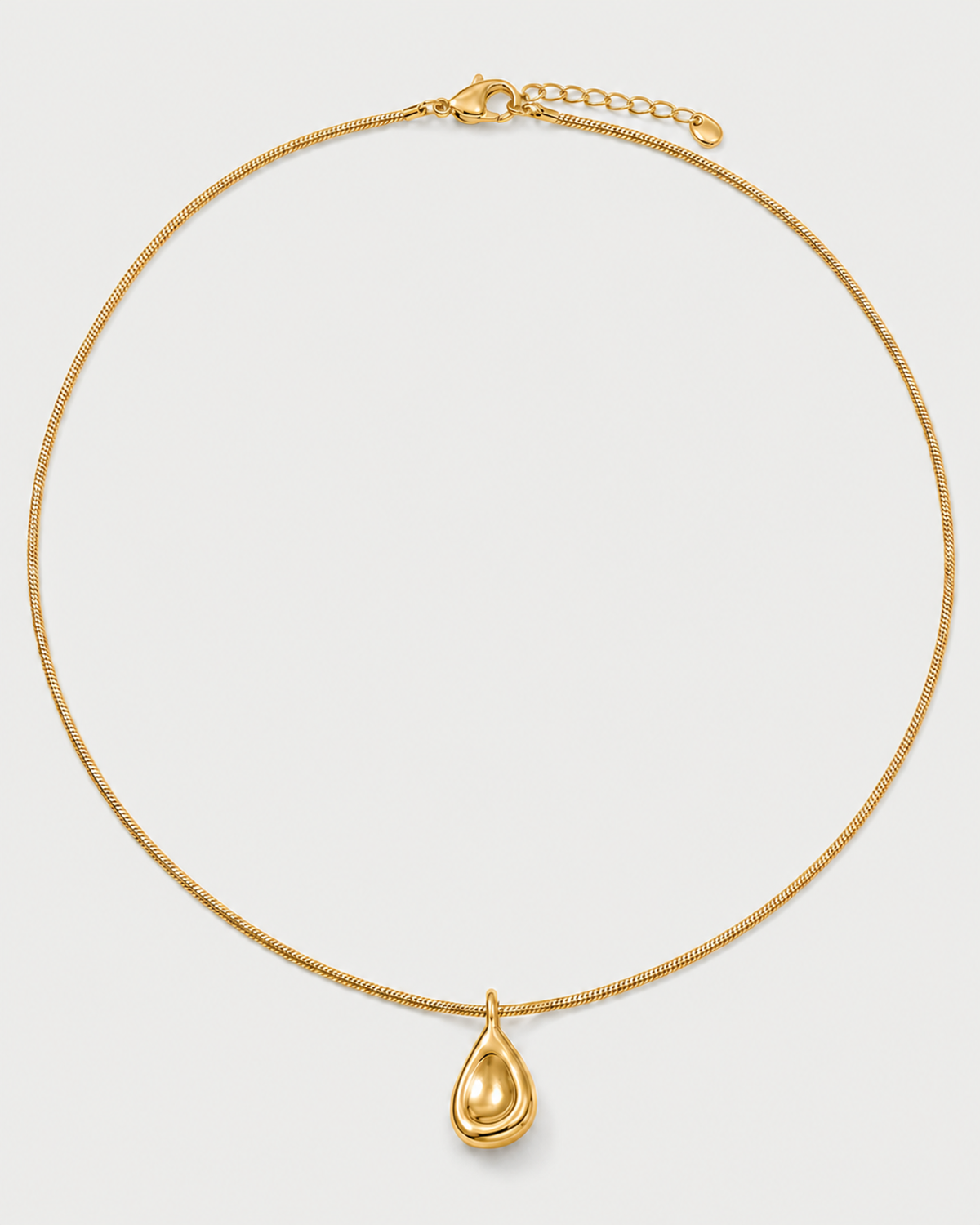 Elara gold sculptural droplet necklace on a seamless pale dove-grey studio background