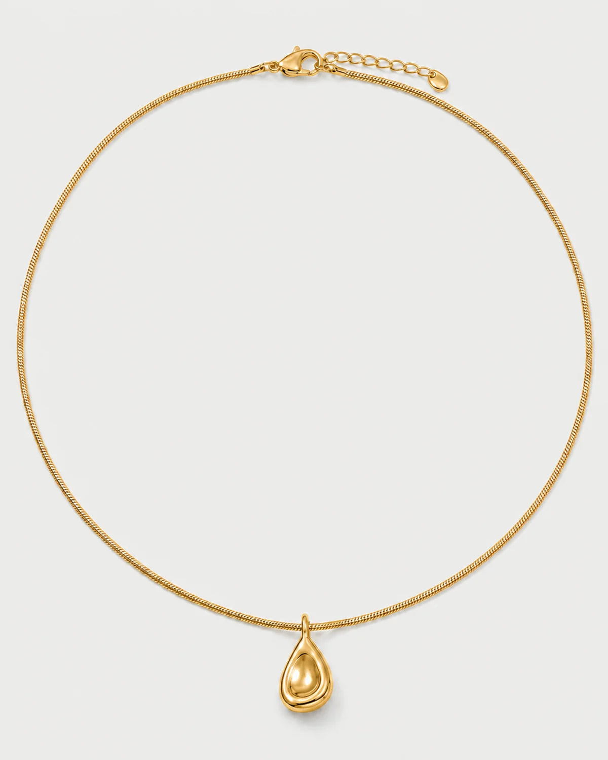 Elara gold sculptural droplet necklace on seamless pale neutral grey