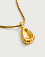Macro of the Elara gold recessed droplet pendant and polished snake chain
