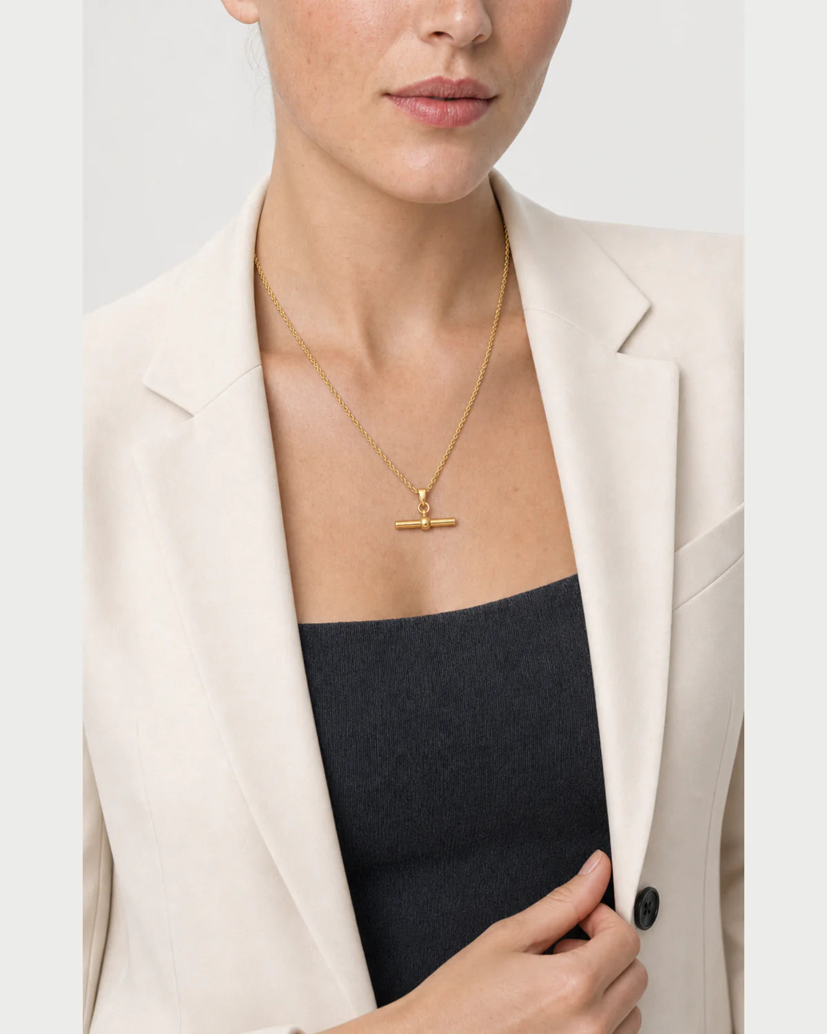 Model holding her blazer lapel while wearing the Elodie necklace