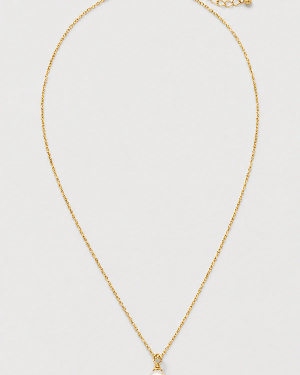 Elowen gold freshwater pearl drop necklace on pale dove-grey