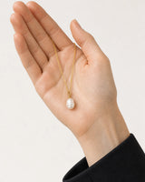 Hand-held scale view of Elowen pearl drop necklace