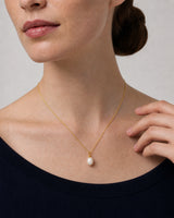 Elowen pearl drop necklace worn with a natural hand near the collarbone