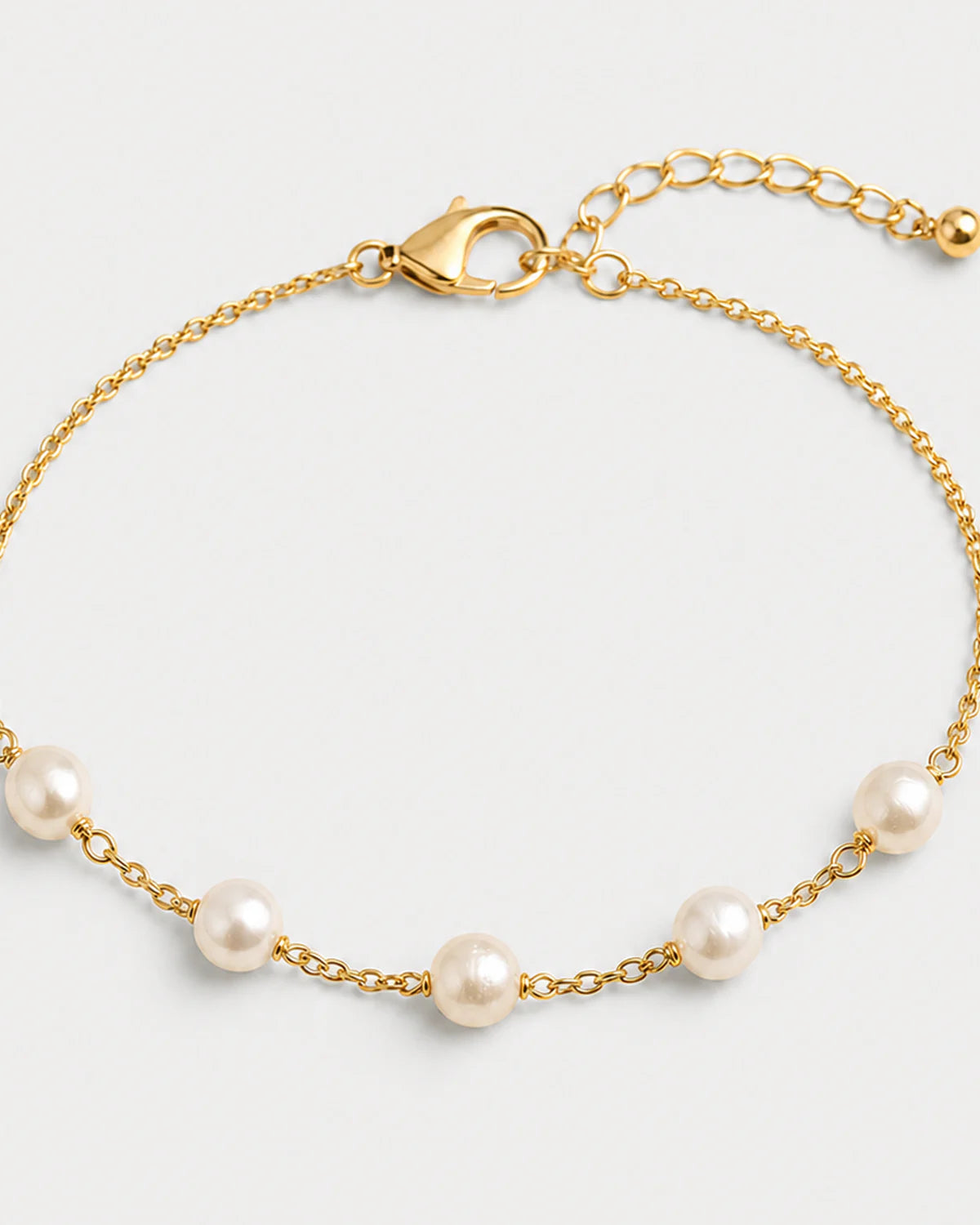 Macro view of three organic Elowen pearls and gold chain