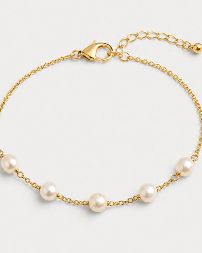 Macro view of three organic Elowen pearls and gold chain