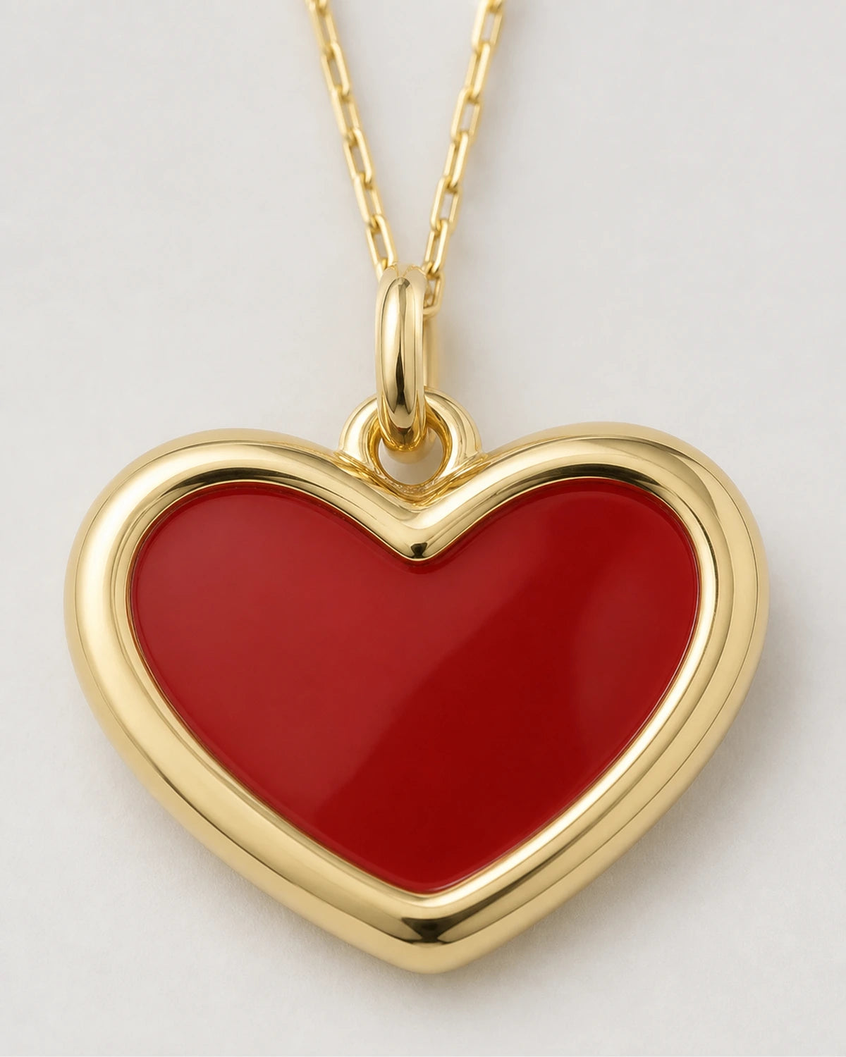 Macro view of the Estelle glossy red enamel heart and gold border