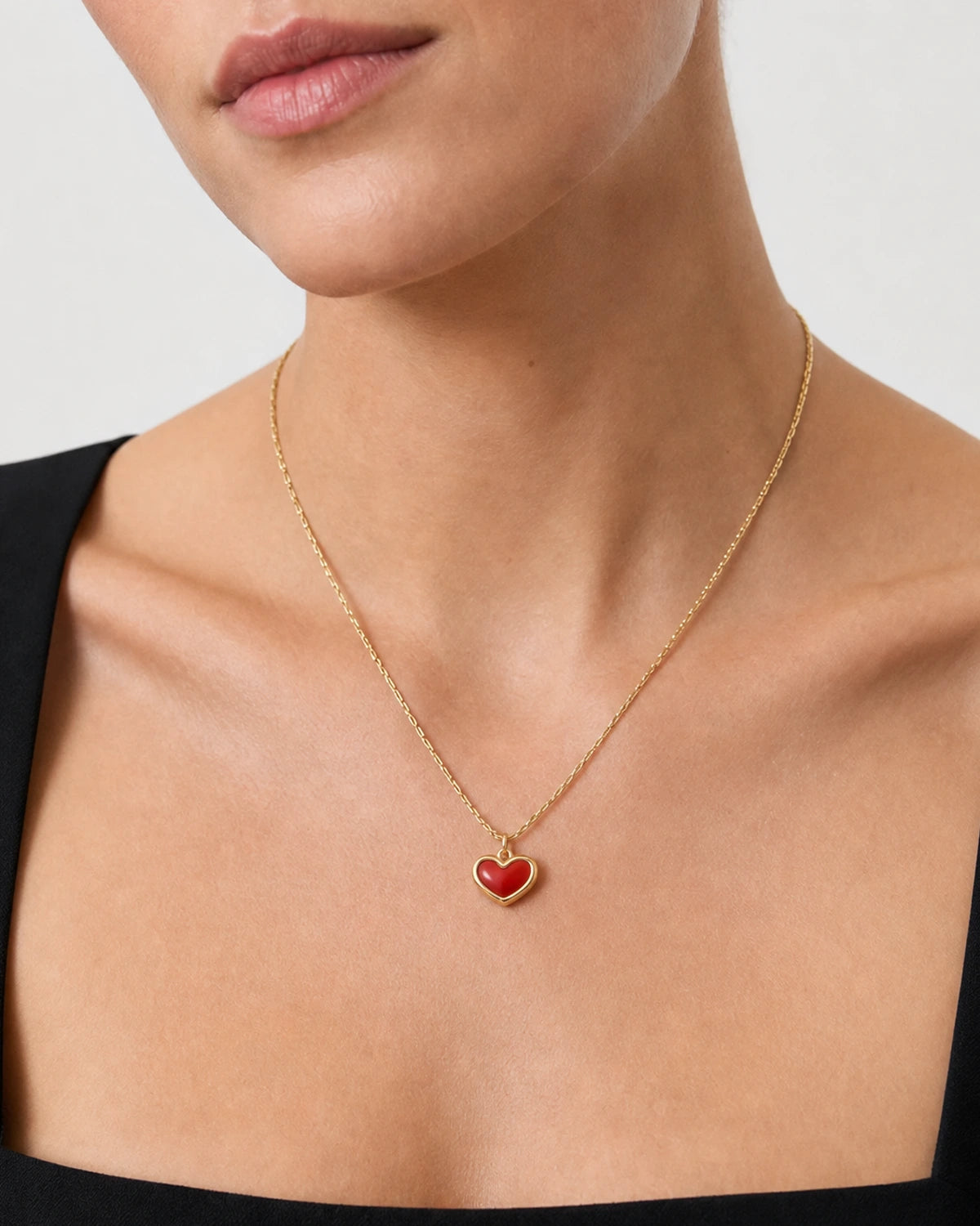 Close neckline view of the Estelle gold red enamel heart necklace