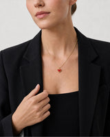 Human-scale wearing detail of the Estelle red enamel heart pendant