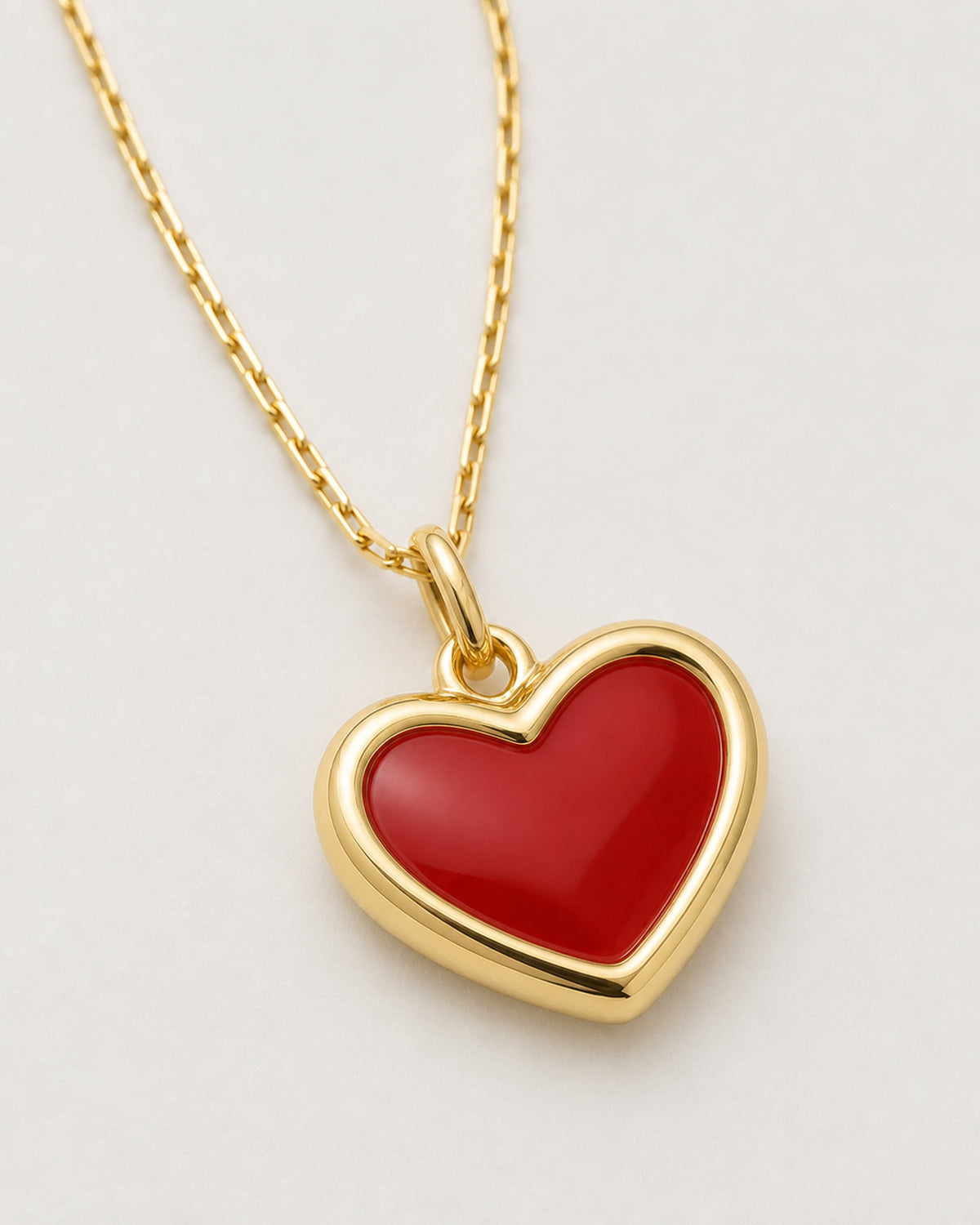 Alternate three-quarter product view of the Estelle red enamel heart necklace on pale neutral grey