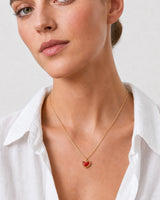 Close summer neckline portrait showing the Estelle red enamel heart necklace