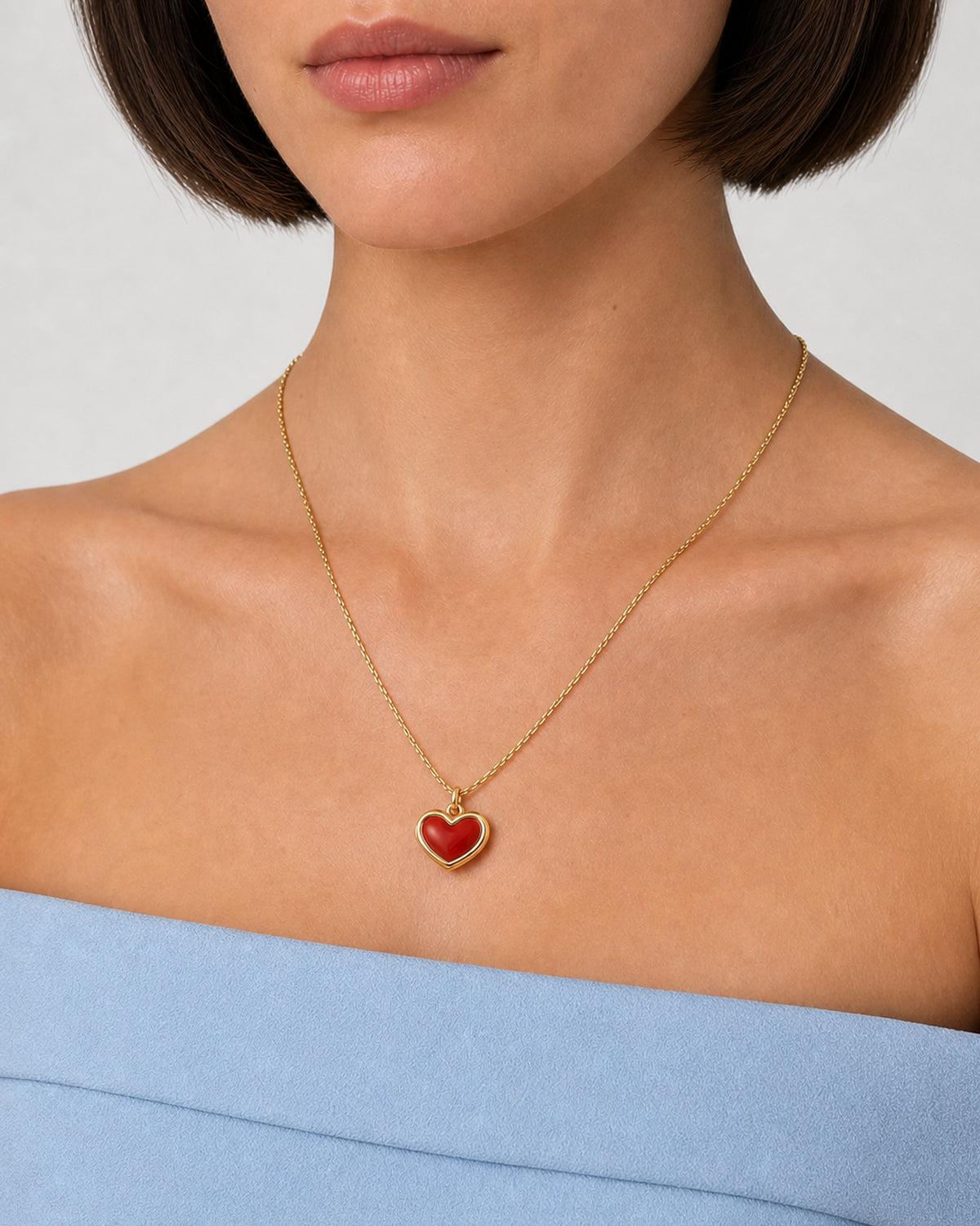 Tight neckline detail of the Estelle gold and red enamel heart necklace