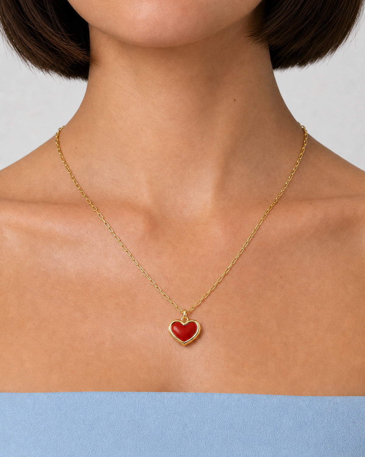 Complete worn macro of the Estelle red enamel heart necklace at natural scale