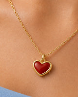 Extreme worn macro of the Estelle red enamel heart, gold border, bail and rectangular-link chain