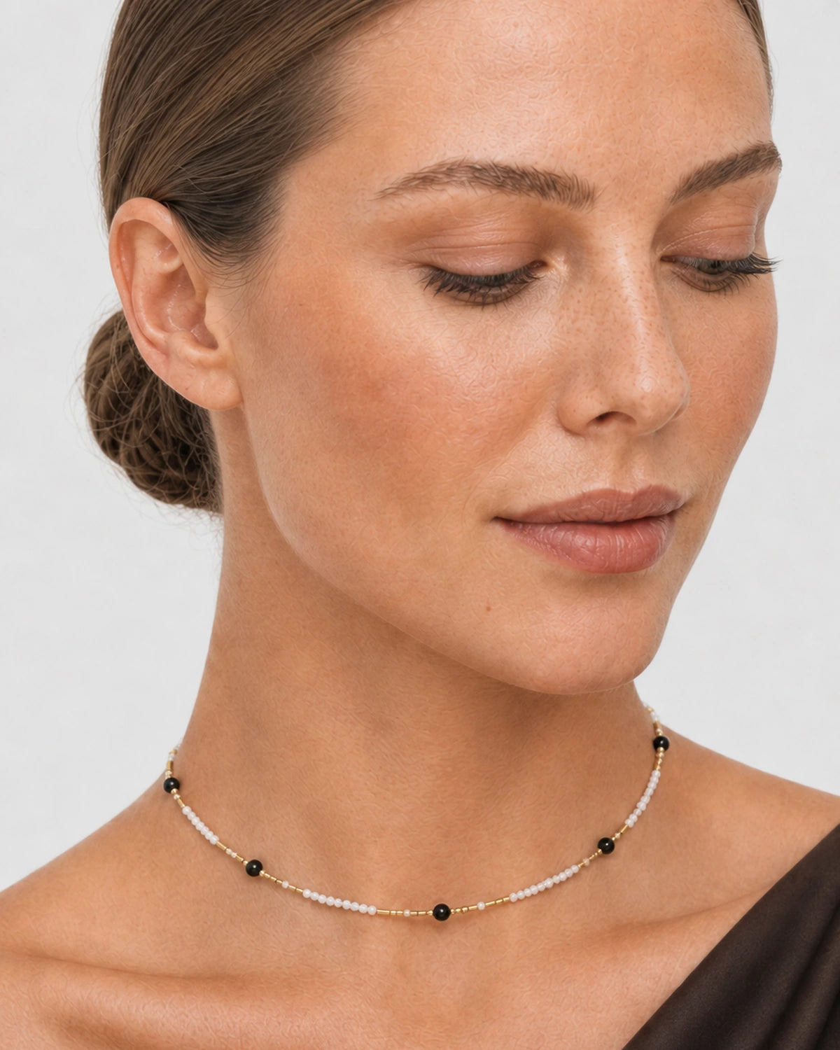 Close neck view of the Isla ivory, black and gold bead rhythm