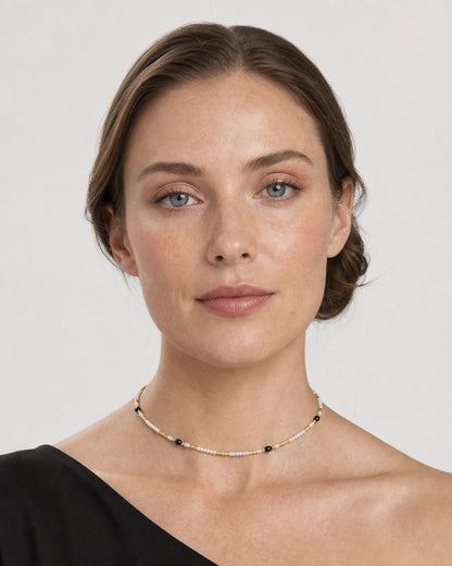 Model wearing the Isla beaded choker in a pale dove-grey studio