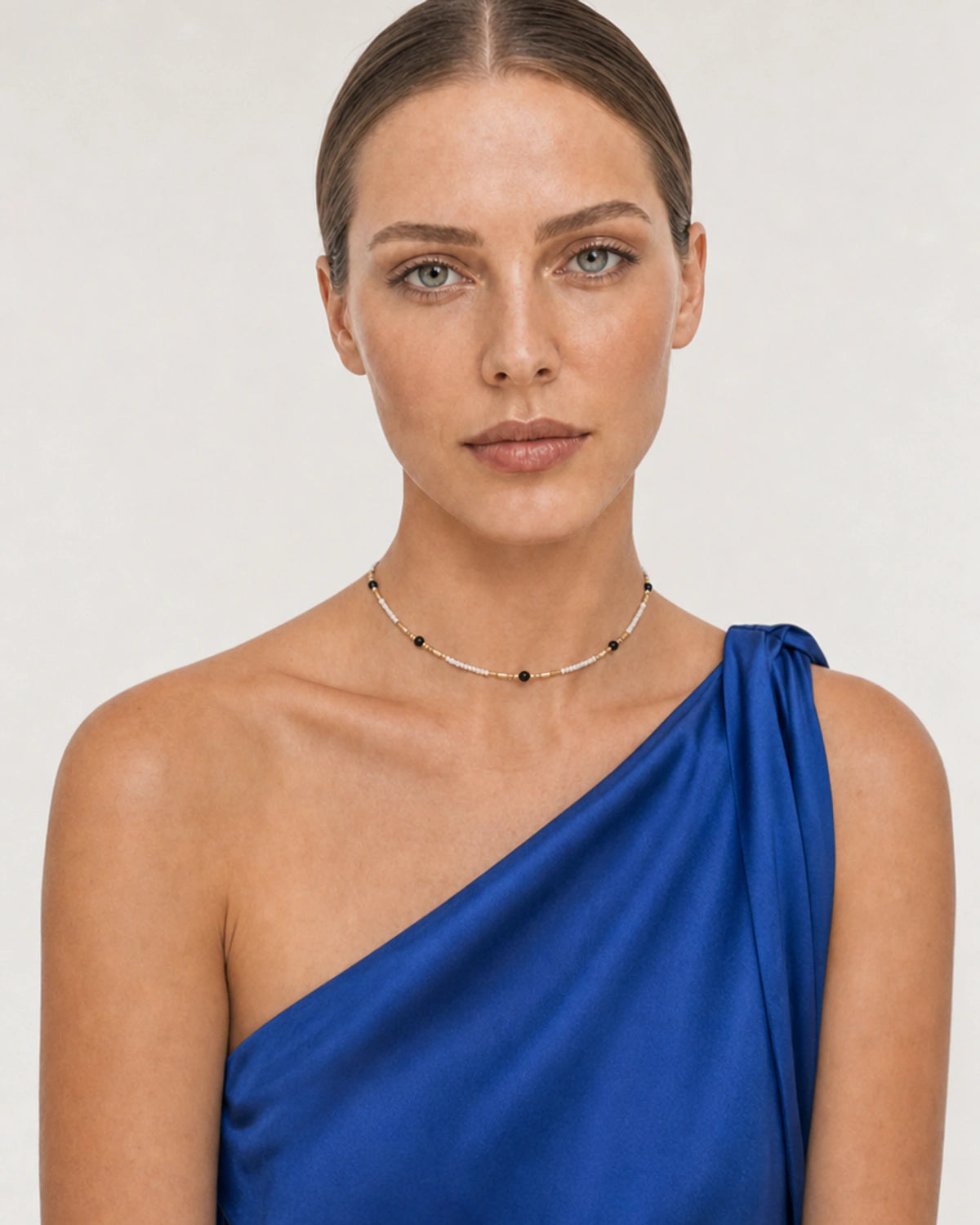 Model in a cobalt Santorini silk dress wearing the Isla beaded choker