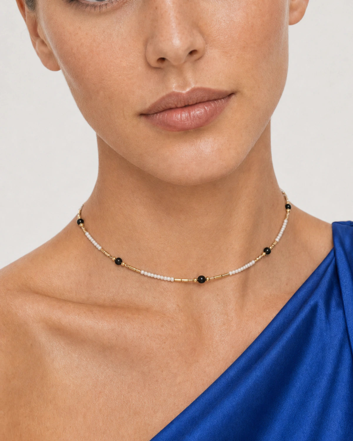 Close wearing view of the Isla ivory seed beads, black accents and gold spacers
