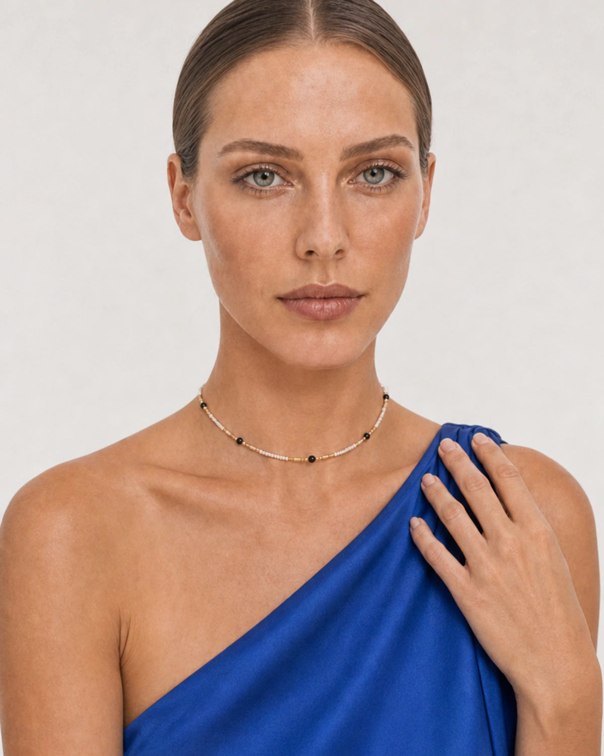 Human-scale cobalt silk portrait showing the fine Isla beaded choker