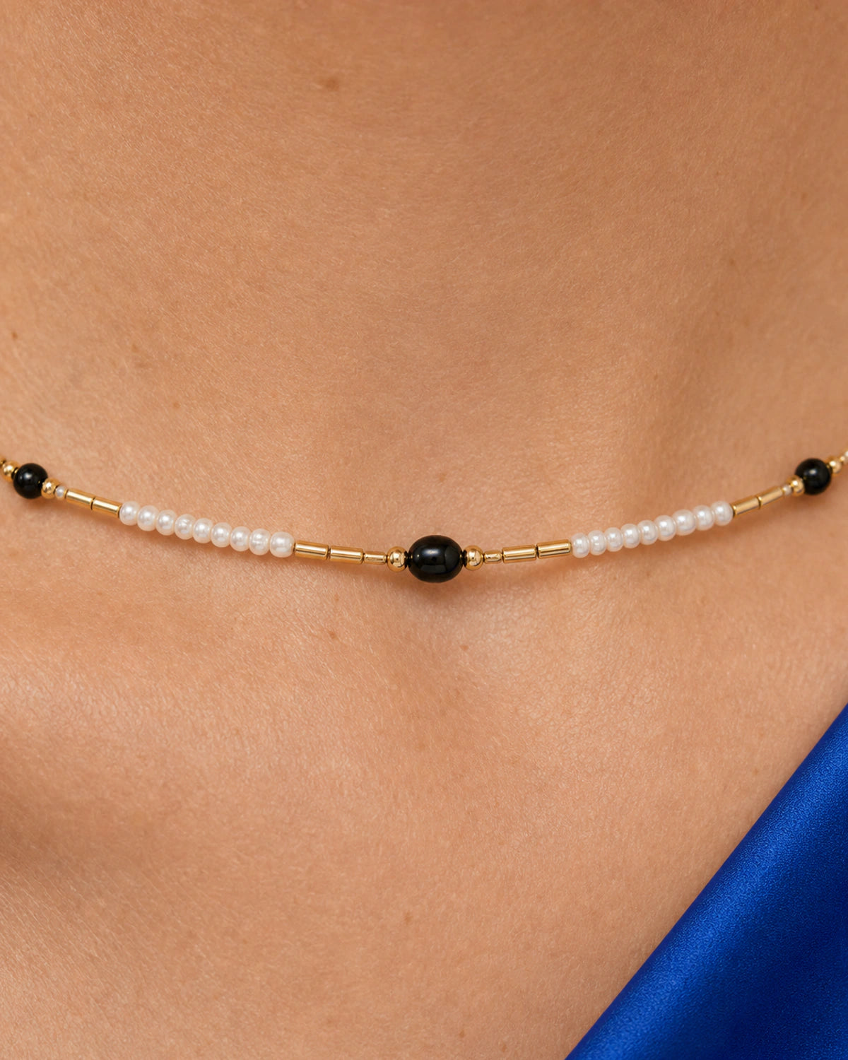 Extreme on-body macro of the Isla ivory black and gold beadwork