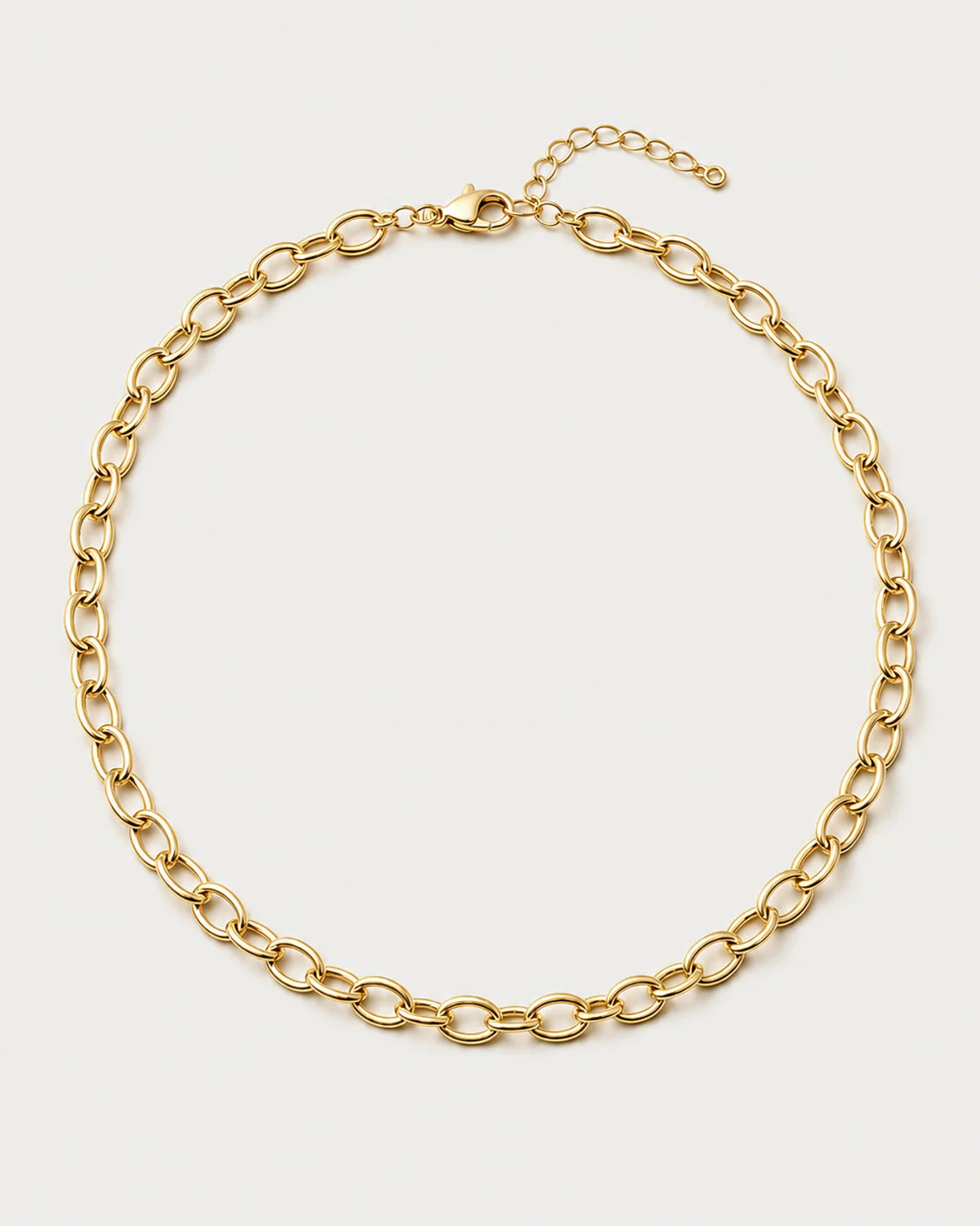Liora gold orbit-link chain necklace on a seamless pale dove-grey background