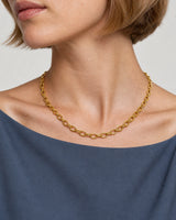 Mouth-down three-quarter wearing view of the Liora gold orbit-link necklace