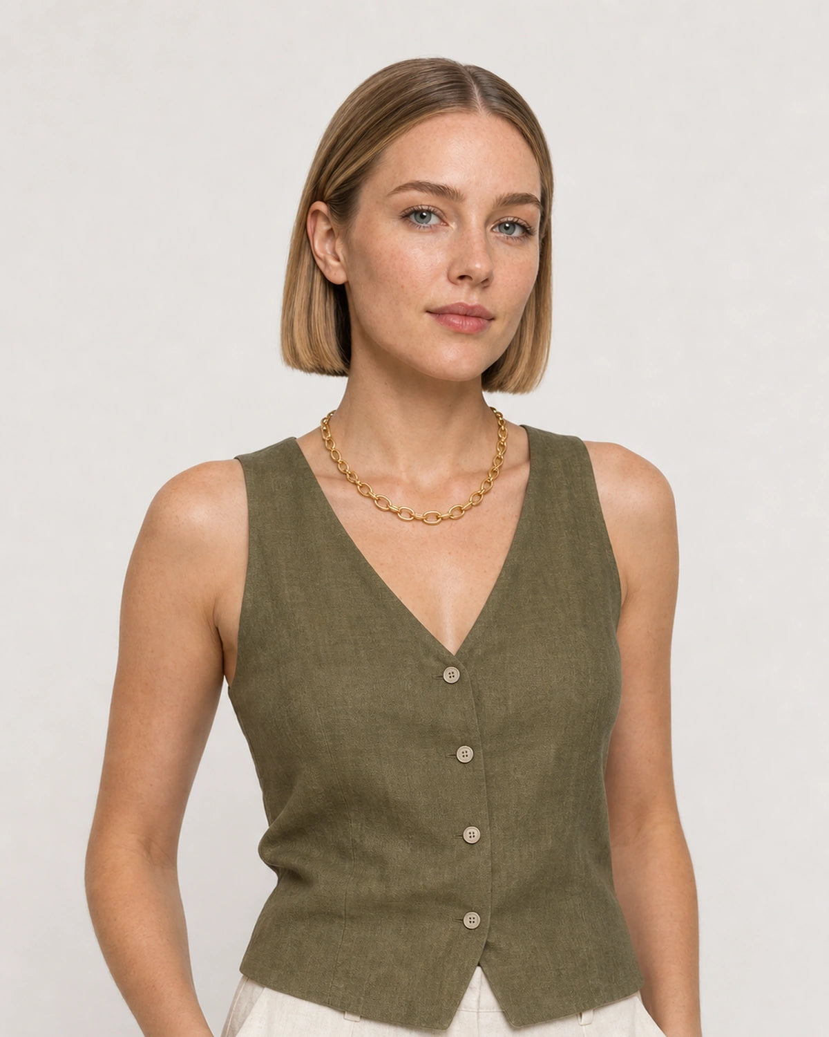 Model in olive and cream summer linen wearing the Liora Orbit gold chain