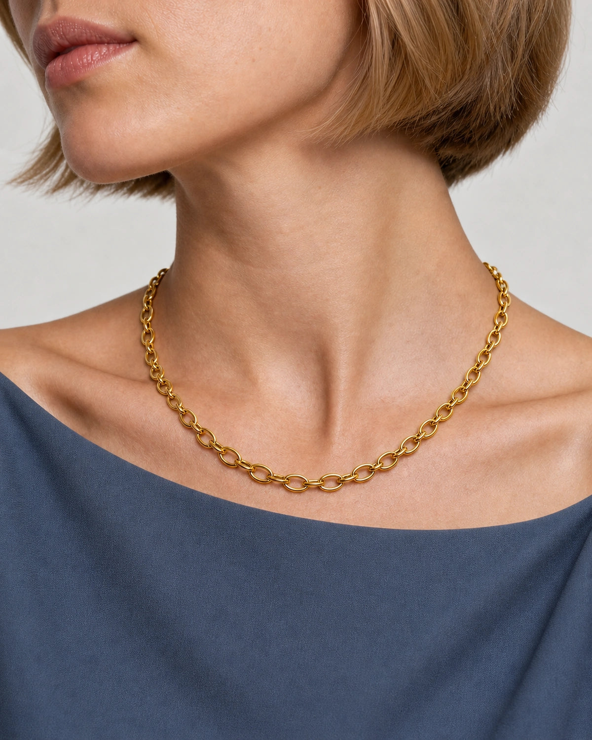 Oblique collarbone detail of the Liora gold orbit-link chain