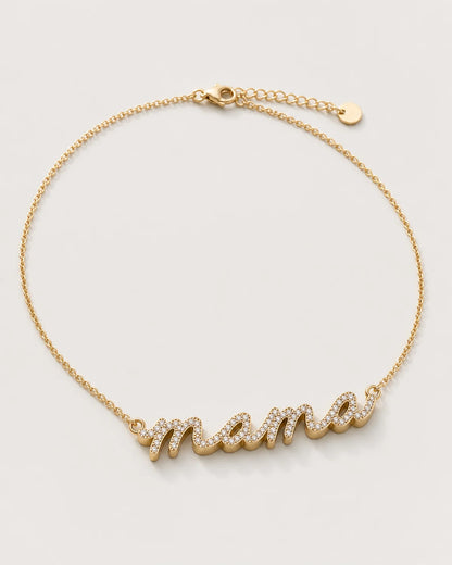 Liora gold sculpted pavé mama necklace on a seamless pale dove-grey studio background