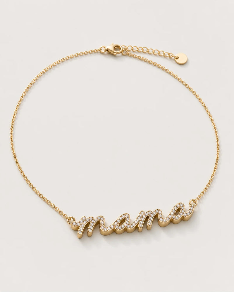 Liora gold sculpted pavé mama necklace on a seamless pale dove-grey studio background