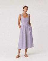 Wide studio portrait in a lavender linen midi dress featuring the Liora mama necklace