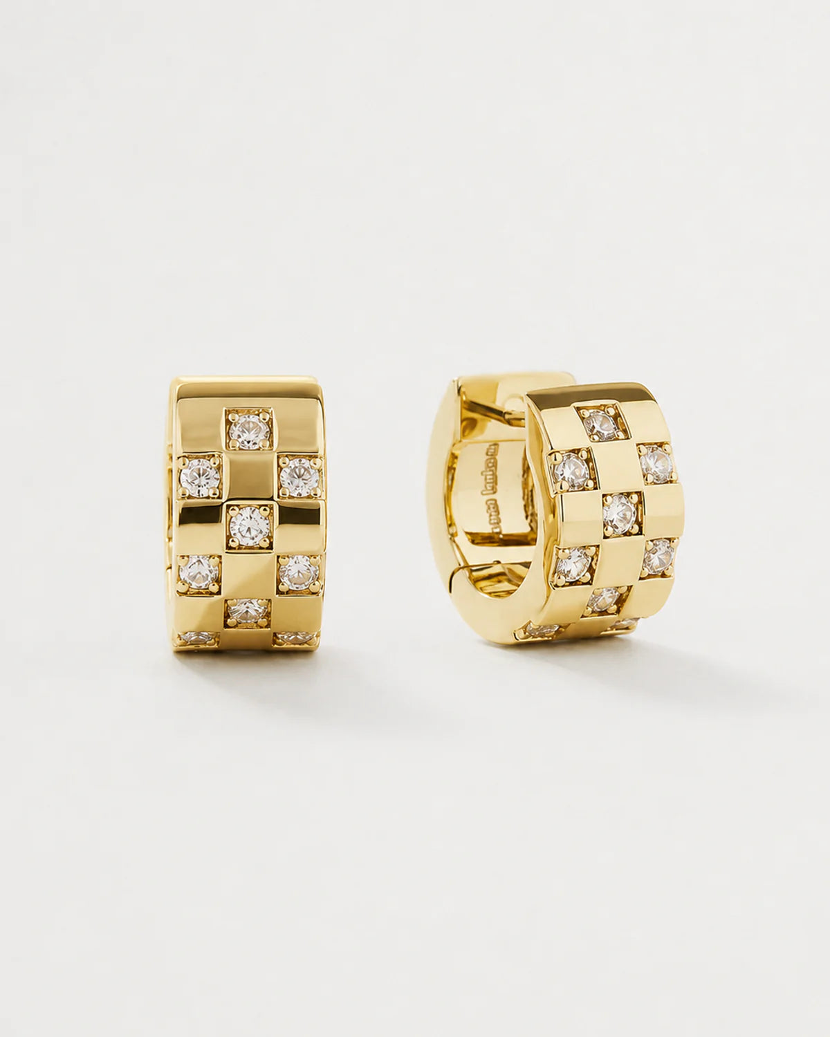 Lisette gold checkerboard crystal huggies on seamless pale neutral grey