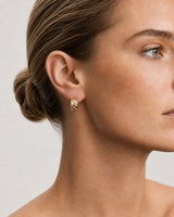 Close side portrait showing one Lisette gold checkerboard crystal huggie