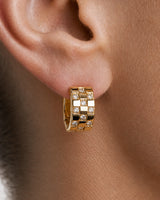 Extreme on-ear macro of a Lisette gold checkerboard crystal huggie