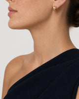 Eye-free profile of Cecily wearing the gold Lisette checkerboard huggie