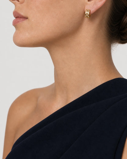 Eye-free profile of Cecily wearing the gold Lisette checkerboard huggie