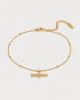 Lucille gold beaded T-bar bracelet on a pale dove-grey background